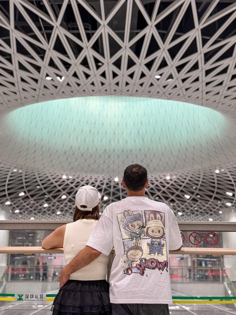 Pareja mirando el Ojo de Shenzhen en la estación de metro Gangxia North, Shenzhen, China