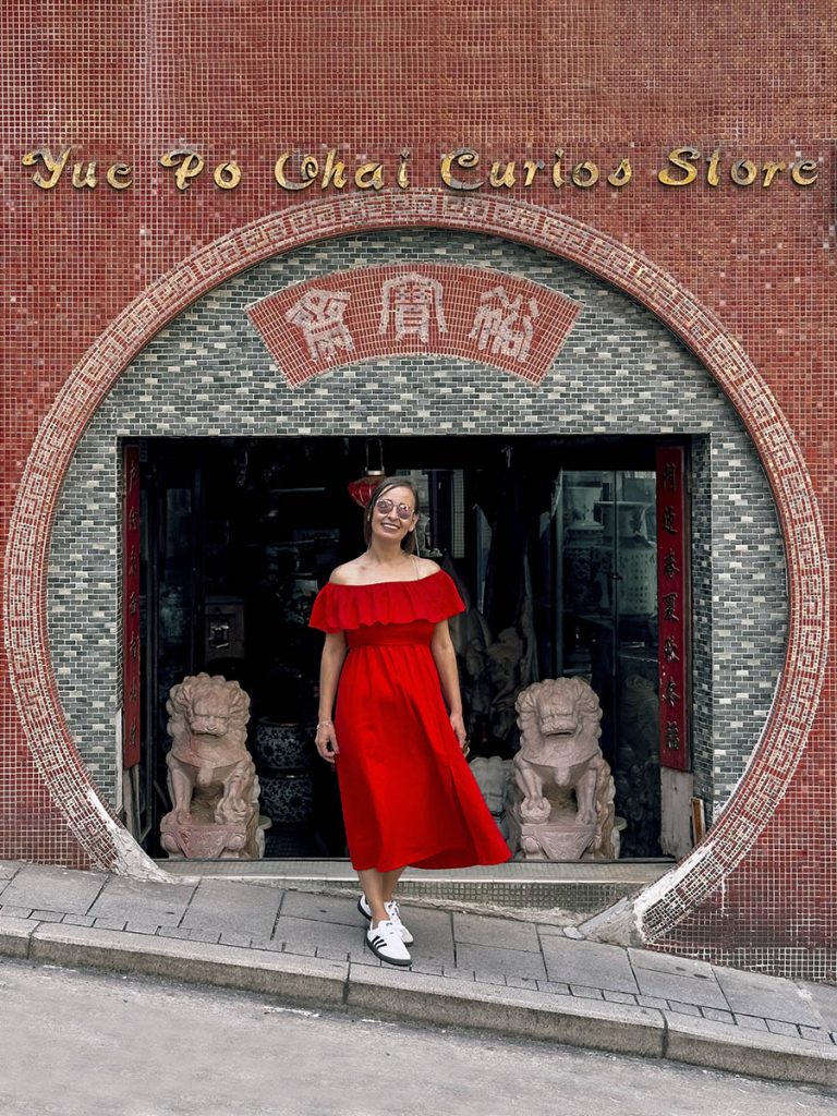 Chica delante de una tienda de antiguedades en Hong Kong
