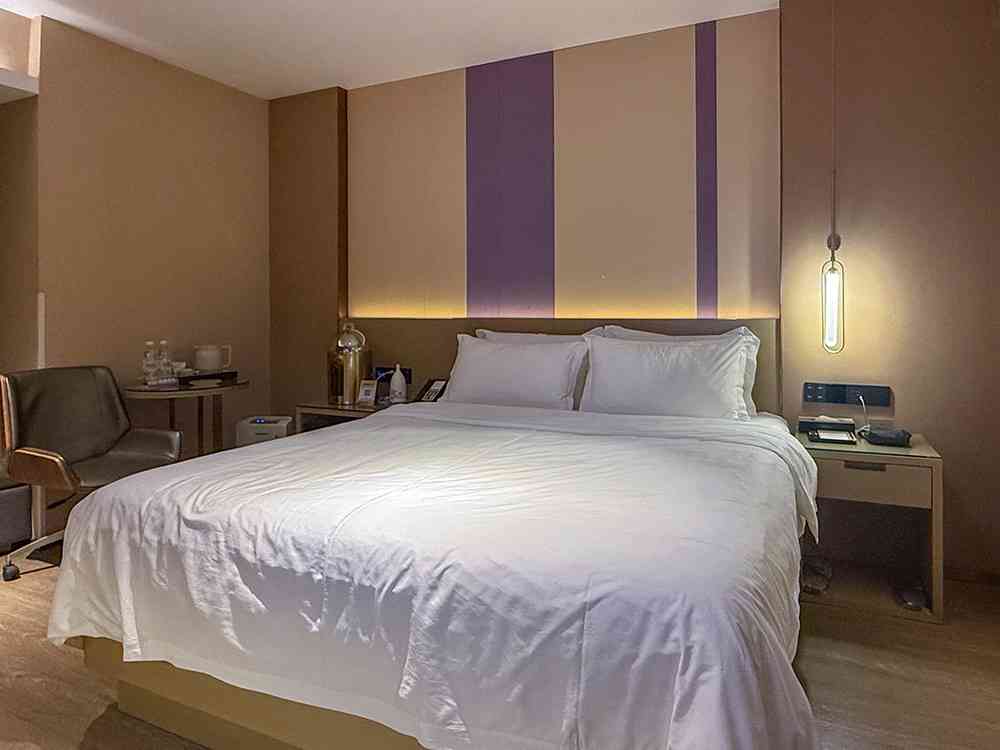 Habitación moderna del Lavande Hotel en Shenzhen, con decoración en tonos morados de lavanda y un ambiente limpio y funcional.