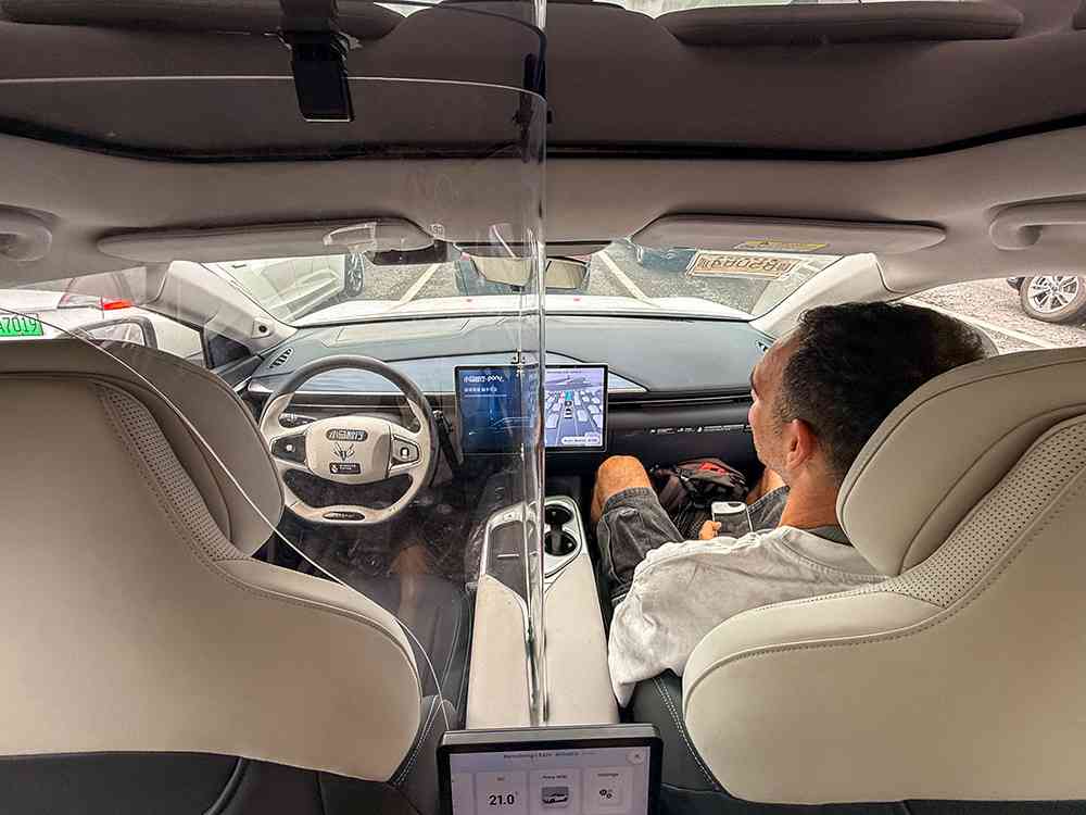 Interior de un coche DiDi en China, con asientos traseros amplios y modernos, ideal para el transporte urbano.
