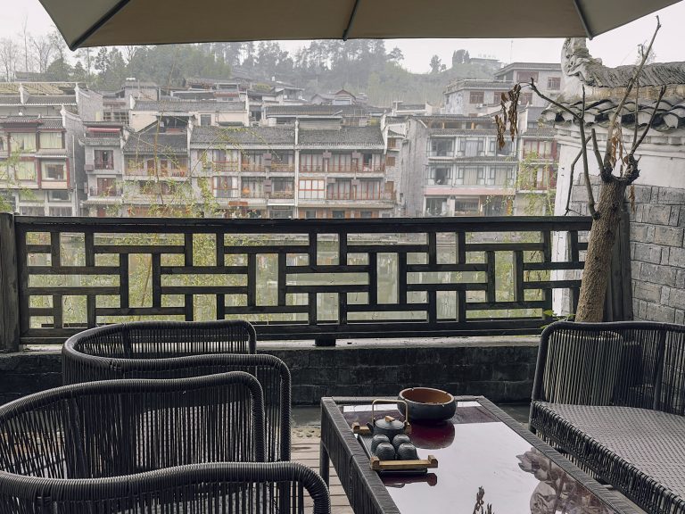 Terraza amplia con vistas panorámicas al río Tuojiang desde el Phoenix Youran Qingsu Hotel en Fenghuang. El balcón ofrece una vista espectacular de las casas colgantes y los puentes del pueblo del Fénix