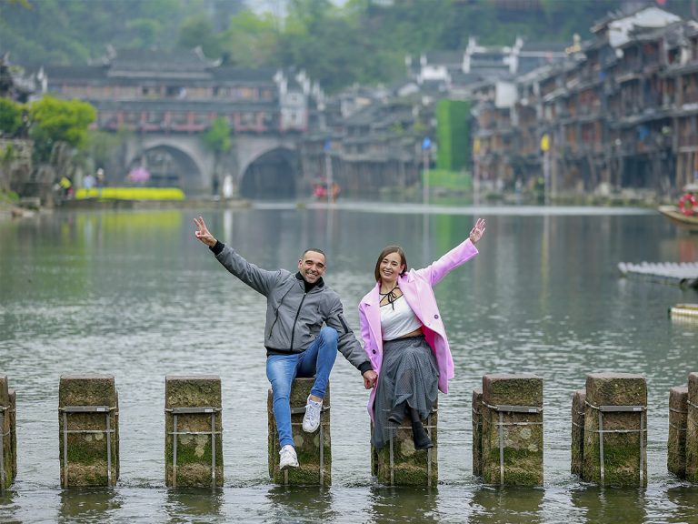 Hilera de pilares de piedra cuadrados del Puente Salto de Roca (Tiaoyan) cruzando el río Tuojiang en Fenghuang. Dos hileras de piedras con el agua corriendo entre ellas, el puente más divertido y fotogénico del pueblo del Fénix con las casas colgantes de fondo