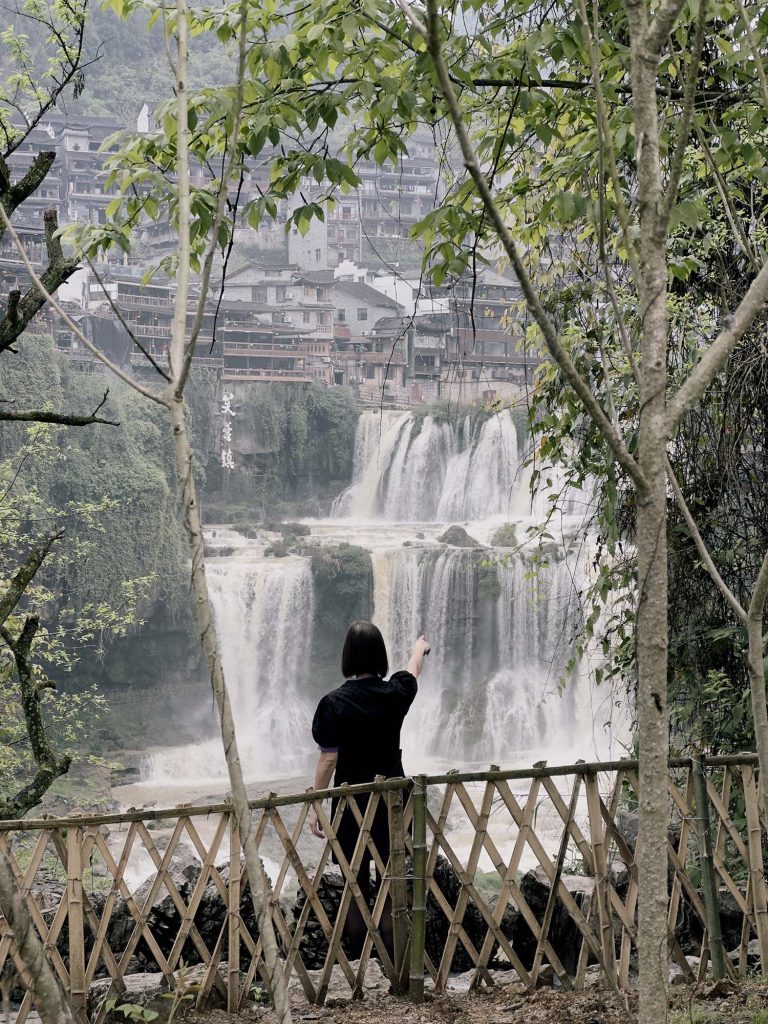 Chica señalando a lo lejos la cascada de Furong