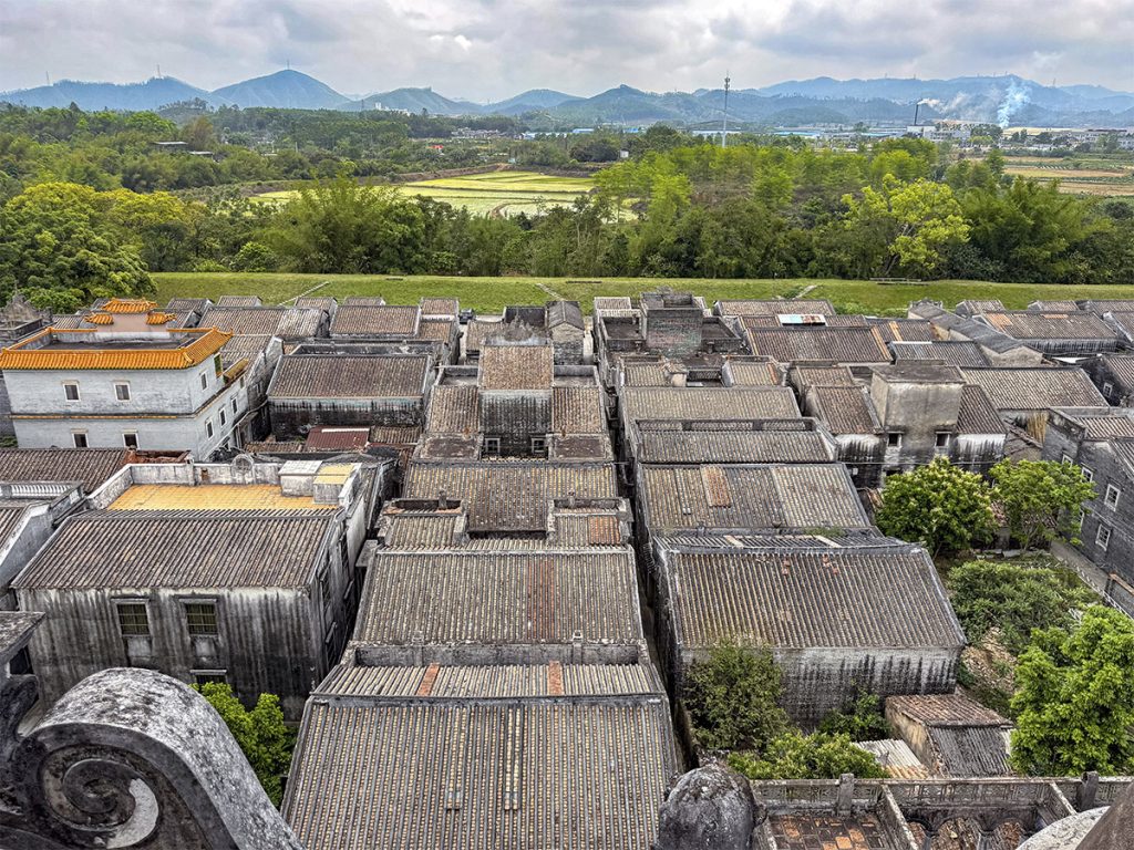 Vista de una aldea rural remota en China, con casas tradicionales rodeadas de montañas y naturaleza. Un paisaje auténtico que muestra la China más profunda y alejada de las grandes ciudades.