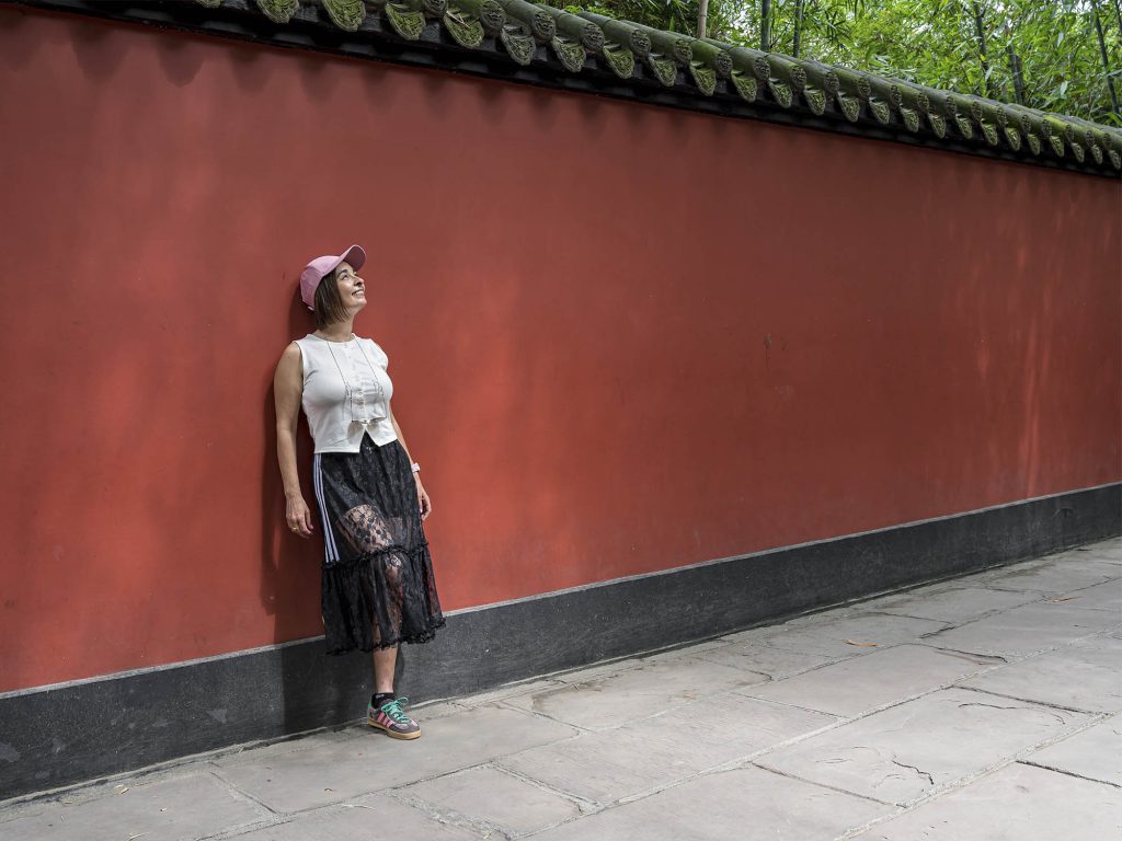 Viajera apoyada en un muro rojo en la calle Jinli de Chengdu, China 2026