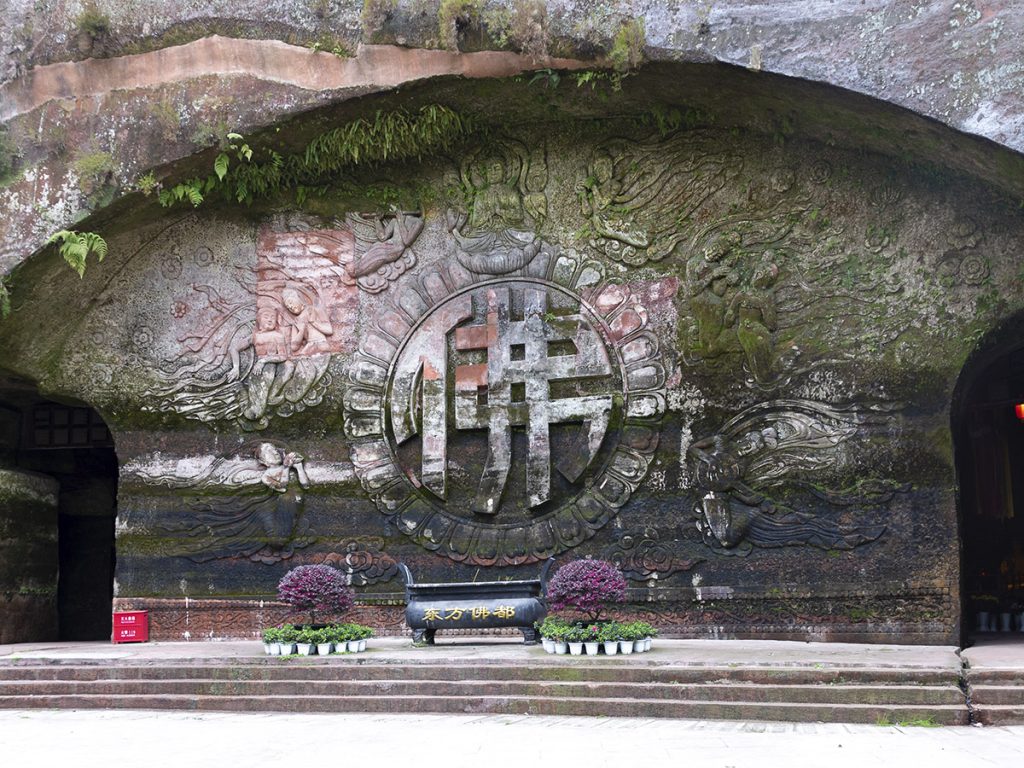 Descubre la imponente entrada a la Cueva de los 10.000 Budas. Una puerta de piedra que da acceso a uno de los conjuntos de arte rupestre budista más impresionantes de China.