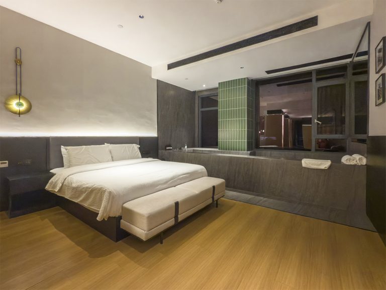 Habitación moderna y elegante en el Leshan L Private Soup River View Hotel, con cama amplia, iluminación cálida, grandes ventanales y vistas al río y a la ciudad de Leshan.