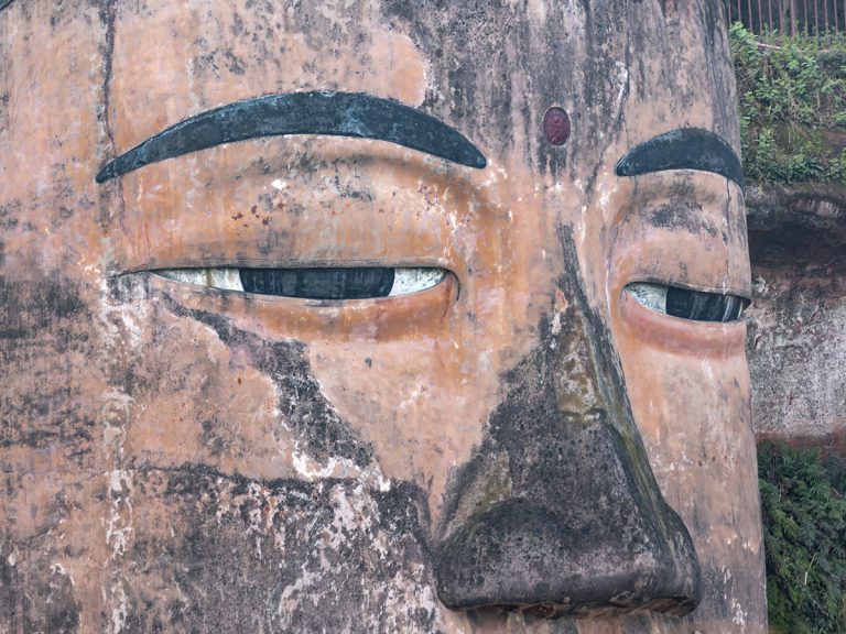 Primer plano de la cabeza del Gran Buda de Leshan, con sus 1021 moños enroscados tallados en la roca y expresión serena, visto desde la plataforma superior
