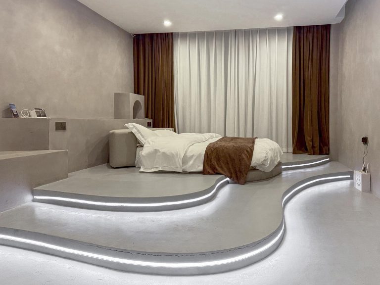 Habitación tipo cueva en el Yinianzhijian Boutique Homestay de Chuanzhusi, con cama king size, techo inclinado, ventana con vistas a la montaña y un diseño rústico de piedra y madera.
