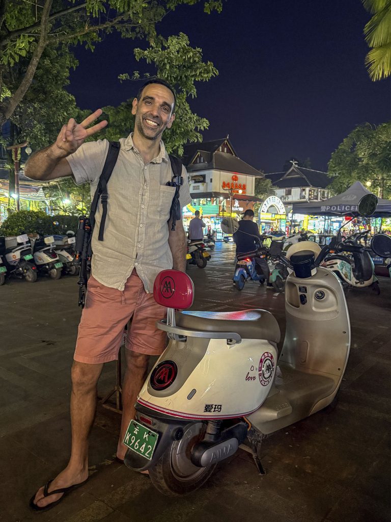 Javi posando con la moto eléctrica de alquiler en Jinghong, Xishuangbanna, China