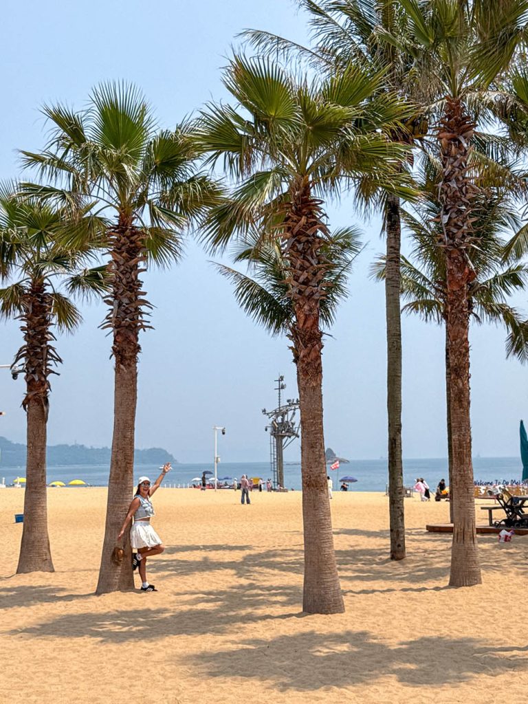 Marta apoyada en una palmera en la playa de Dameisha Beach, Shenzhen, China