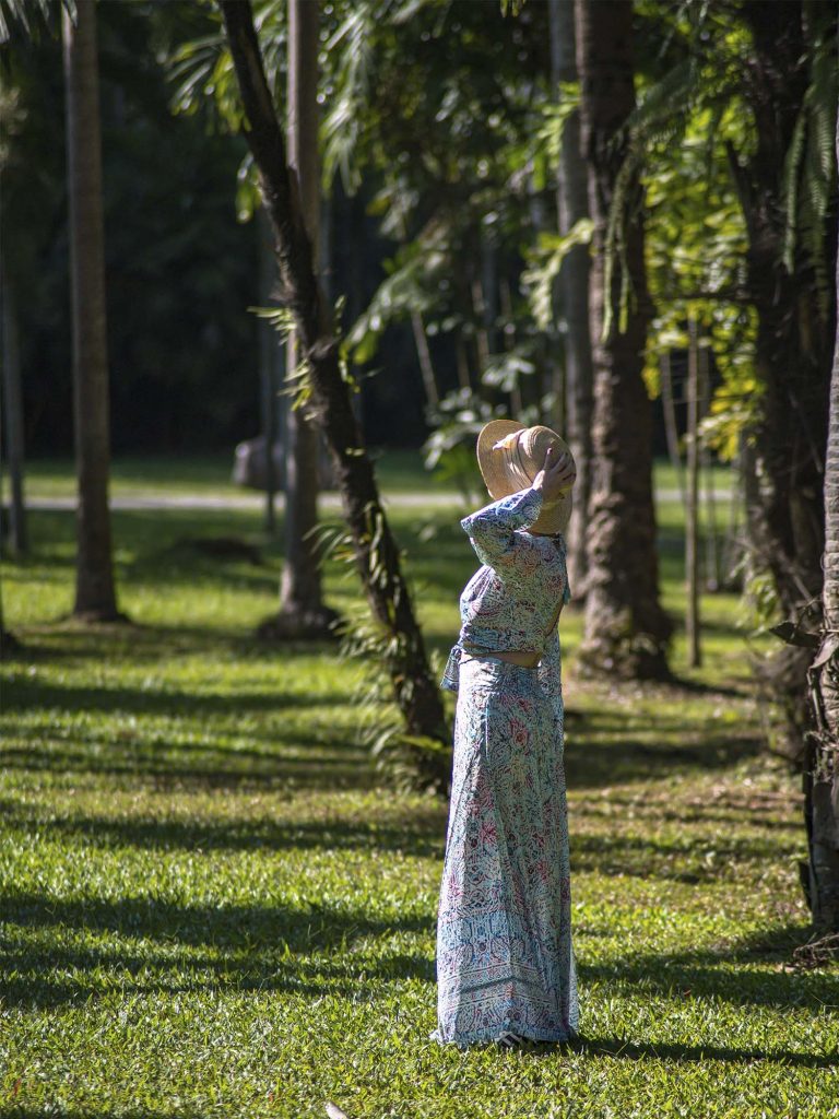 Marta paseando entre grandes palmeras en el Jardín Botánico Tropical de Xishuangbanna, China