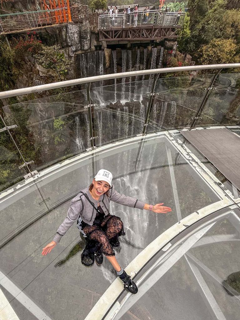 Marta sentada en la plataforma con suelo de cristal de Gulong Gorge, Qingyuan, China
