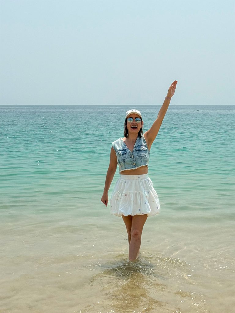 Marta saludando desde el agua en la playa de Dameisha, Shenzhen, China