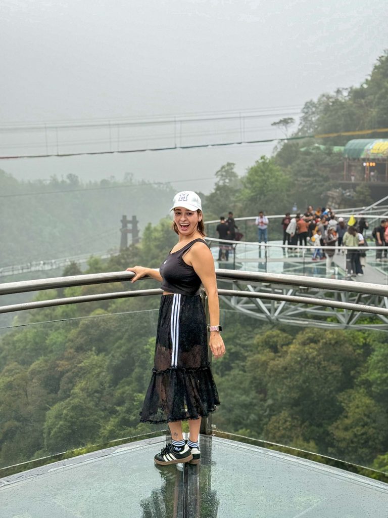 Marta sonriendo sobre la plataforma con suelo de cristal de Gulong Gorge, Qingyuan, China