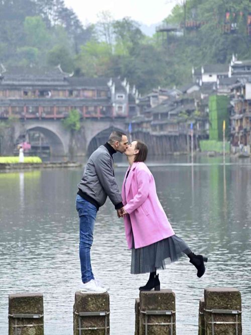 Dos hileras de pilares de piedra del Puente Salto de Roca (Tiaoyan) cruzando el río Tuojiang en Fenghuang. Las rocas cuadradas, con el agua corriendo entre ellas, son el puente más divertido y fotogénico del pueblo del Fénix, con las casas colgantes de fondo