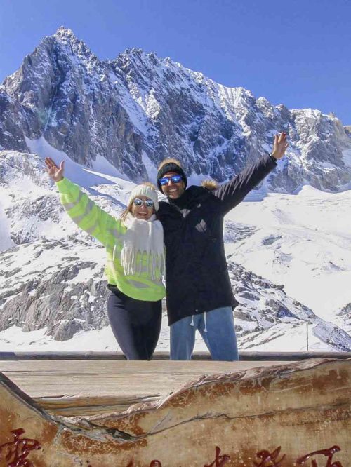Marta y Javi en la cima de la Yulong Mountain, también conocida como Montaña del Dragón de Jade, a 4.860 metros de altitud en la provincia de Yunnan, China. Detrás de ellos se ven los picos nevados y el glaciar de esta impresionante montaña cerca de Lijiang.