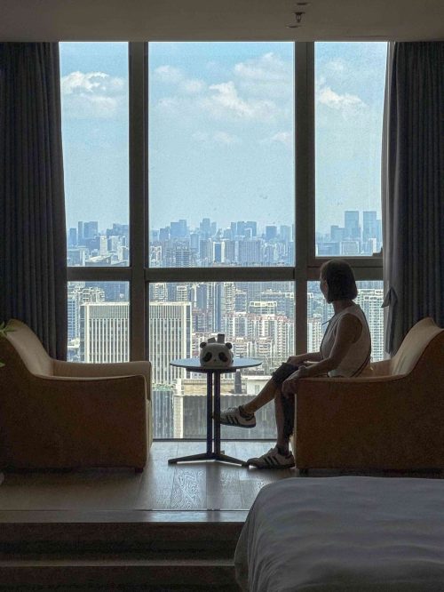 Vista panorámica del skyline de Chengdu desde una habitación en el piso 42 del Rong Zhijia Apartment (Chengdu Global Center Cube), con rascacielos modernos, la ciudad extendiéndose bajo un cielo despejado y el Global Center visible al fondo.