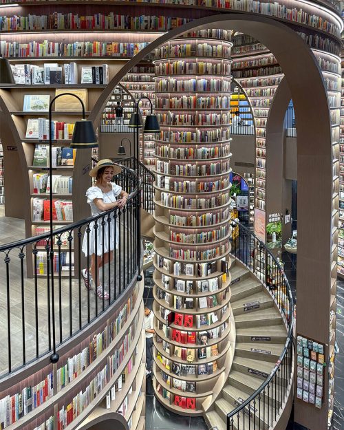 Vista del techo con espejos en la librería Zhongshu de Dujiangyan, con los libros reflejados creando un efecto de infinito, un diseño que simula un laberinto surrealista de conocimiento.
